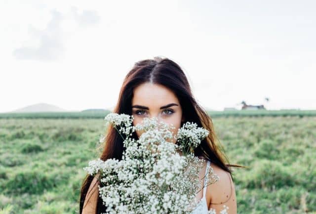 Mladá žena na lúke plnej kvetov