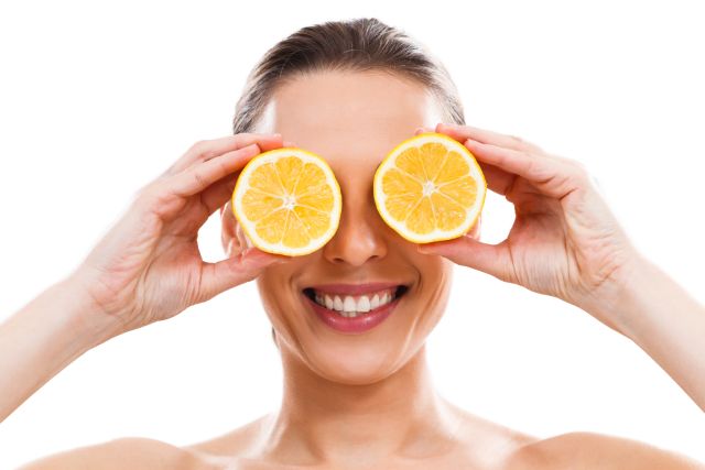 Žena s plátkami pomaranča na očiach