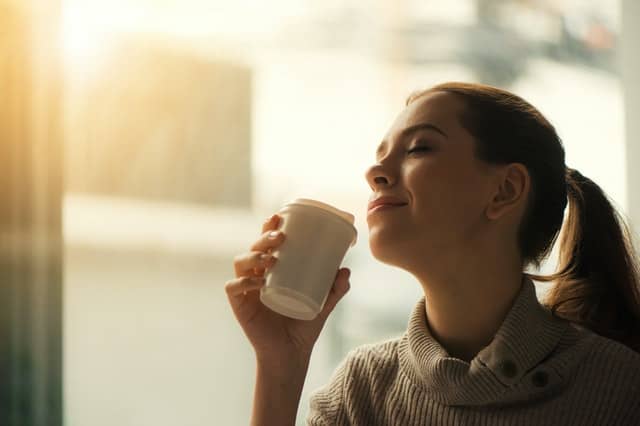 Mladá žena pije kávu